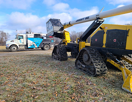 Yellow tracked truck with a boom.