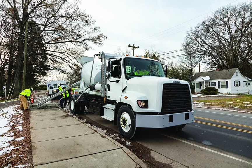 White cement mixer truck on a street.