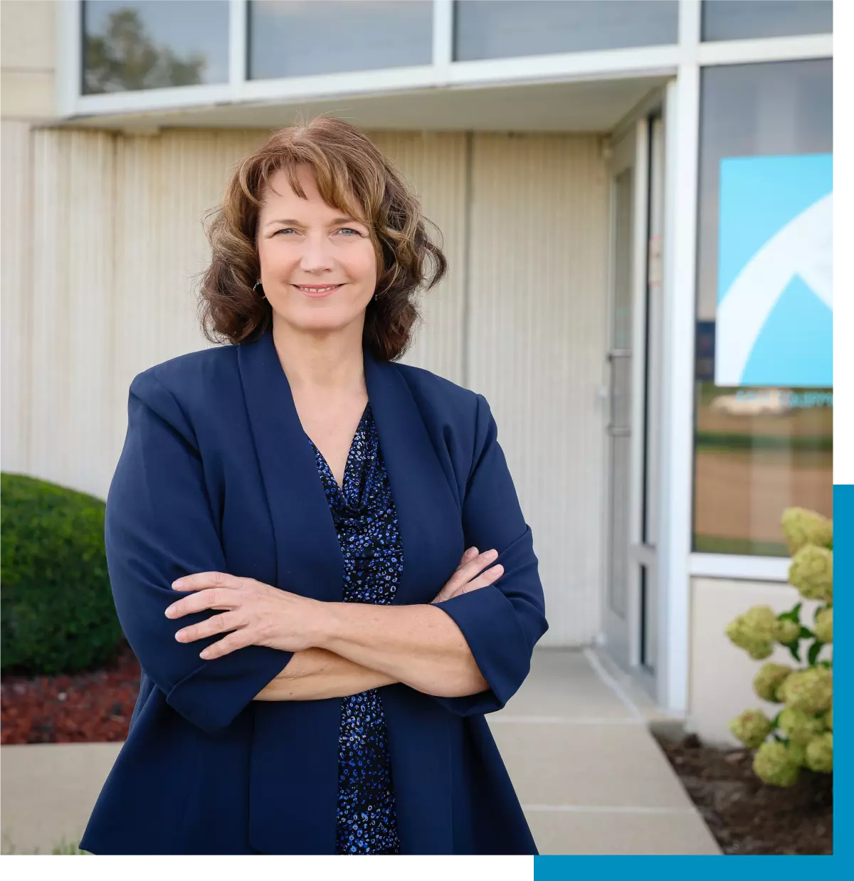 Businesswoman in blue blazer, arms crossed.