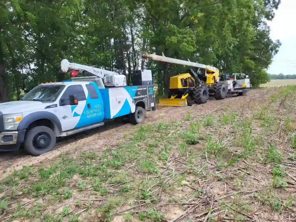 White truck and yellow utility vehicle in field.