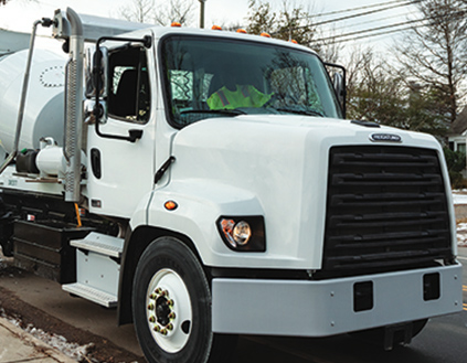 White concrete mixer truck on road.