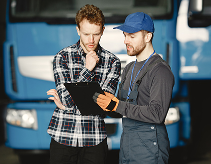 Two men discuss a truck repair.